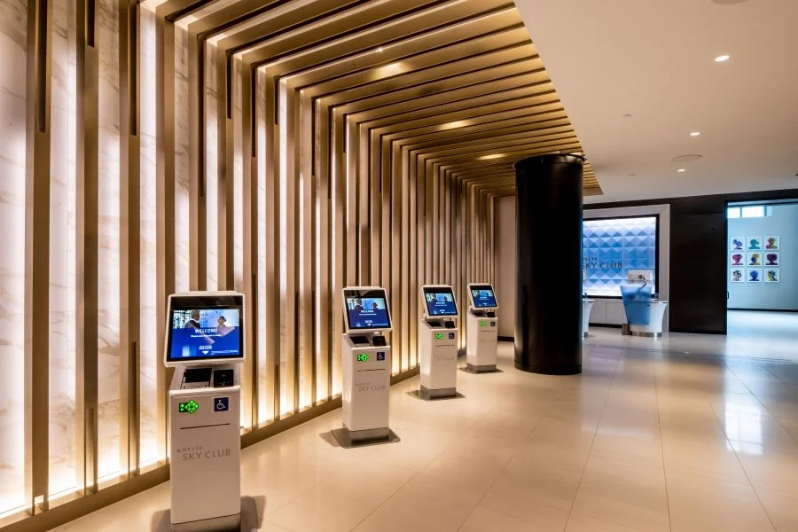 LuxShuttle private car service to Delta Sky Club Concourse T at Hartsfield-Jackson Atlanta — modern check-in kiosks and illuminated entrance