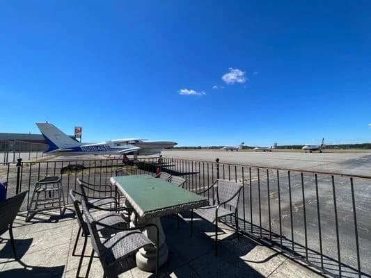 LuxShuttle private chauffeur transfer to The Flying Machine — on-field airport dining with runway views at Briscoe Field LZU