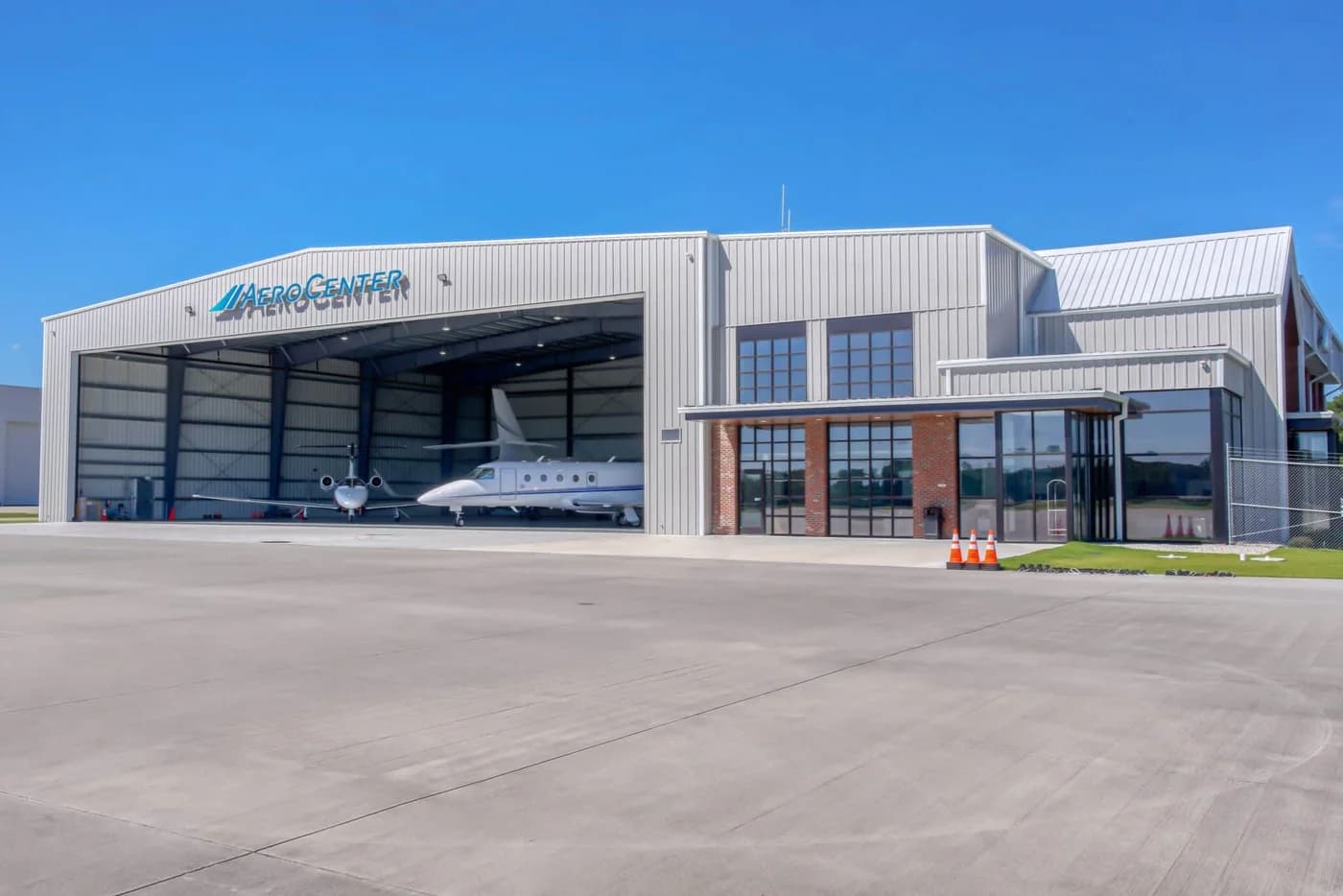 LuxShuttle luxury transfer to Signature Flight Support FBO at DeKalb-Peachtree Airport — modern aviation facility with business jet on ramp