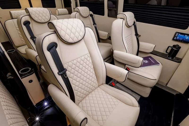 LuxShuttle interior — rear cabin with cream quilted leather and ceiling lighting